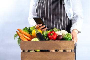 Farm organic market shopping concept, Wooden box with summer, autumn raw vegetables and fruits, in farmer womans hands on white background