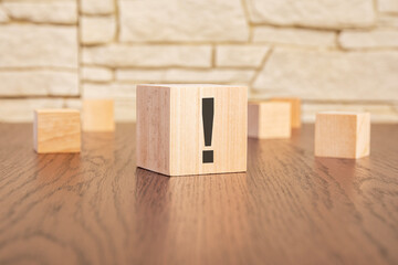 wooden blocks with exclamation point on wooden table, close up. space for text