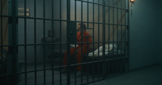 Female prisoner talking phone in prison. Women serve imprisonment term in jail. Detention center or correctional facility.