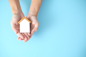 Property, house insurance protection concept. wood model house in hands. house care.