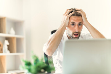 Mature business man using laptop computer in office look like frustrated