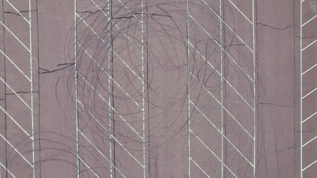 Car tire marks left on asphalt in car parking lot, top down shot. High quality 4k footage