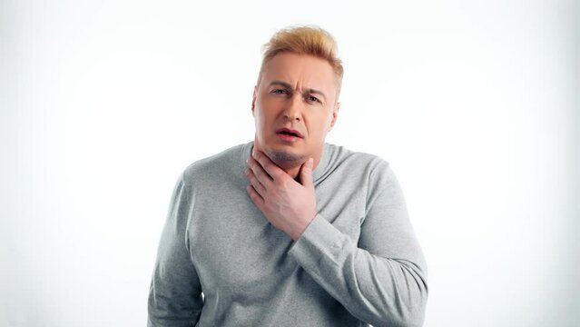 Man, sore throat and pain with medical, health or wellness problem. Sick unhappy ill guy male with hand on neck for allergies or virus, healthcare in studio isolated on white background