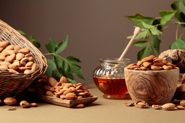 Naklejka na ściany i meble Almond nuts and honey on a brown background.