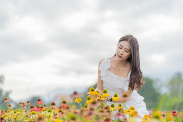 Fototapeta na wymiar Young Asian woman traveling in a colorful flower garden in Chiang Mai, Thailand.
