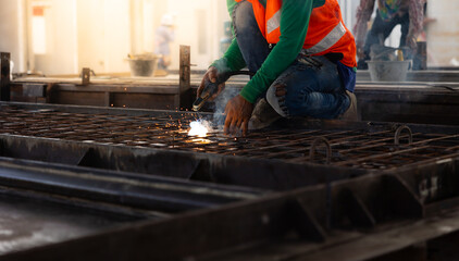welding. Asian man worker weld metal with a arc welding machine at the construction site. Heavy...