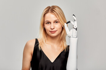 Studio portrait of beautiful young blonde girl with disability wearing sensory bionic prosthetic...