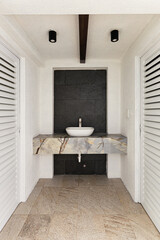 White exterior bathroom sink with grey wall stone