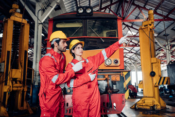 Team of engineer railway wearing safety uniform and helmet under checking under train ,wheels and control system for safety travel passenger. Maintenance cycle concept.