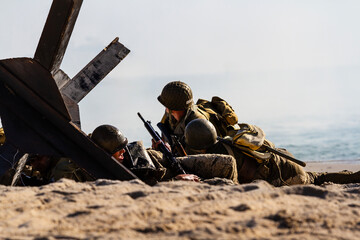 Historical reconstruction. An American infantry soldiers from the World War II  fighting on the beach between smoke and dust. © krysek