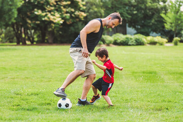 Young soccer player having fun on a field with his father