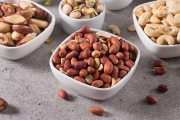 Healthy mix nuts on wooden background. Almonds, hazelnuts, cashews, peanuts, pistachios, Brazilian nuts