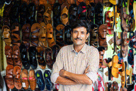 Indian man selling footwear or chappal at roadside shop