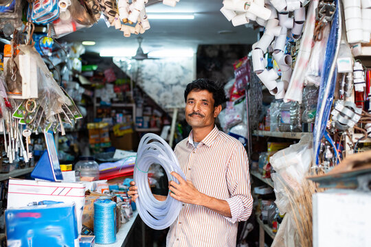 Indian hardware shop owner, salesman, vendor or seller showing products, customer service concept