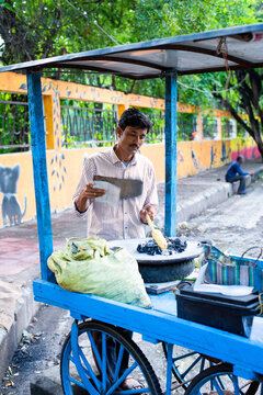 Indian street seller selling roasted corn or bhutta