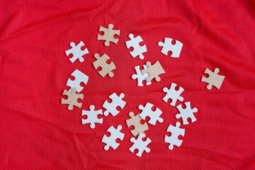 Jigsaw puzzle white color pieces on Colorful athletic Jersey texture, Sports jersey clothing fabric. Copy Space. Fabric texture with holes and white puzzle Jigsaw