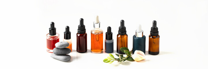 Different dropper bottles with face serum, oil, vitamin acid on isolated background. Natural skin care concept
