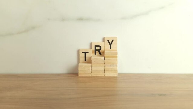 Word try made from wooden blocks. Purpose and movement to success despite obstacles