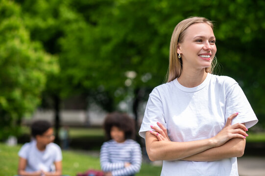 Smiling blonde gorl standing with her arms crossed