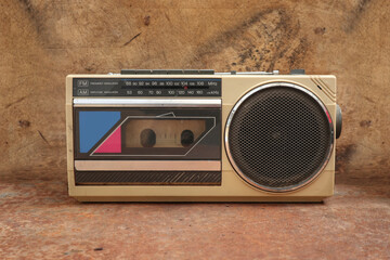 A photo of an old Mono Mini  Cassette Tape Recorder with an rusty background 