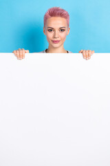 Vertical portrait of gorgeous nice person stand hide behind empty space advert blank isolated on blue color background