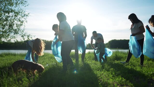 group of volunteers clean up the trash. environmental protection ecology cleaning from garbage plastic concept. group people volunteers collects plastic world bottles garbage in bags silhouette