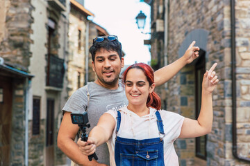 Young couple vlogging and recording a video while doing rural tourism in a mountain village. Holiday trip and outdoor summer vacation in Huesca, Spain