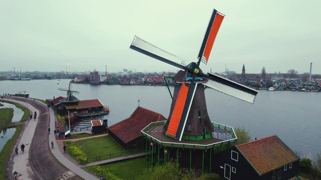 A moving windmil of the Zaans Museum in Amsterdam, Netherlands. Riverbank concept. High quality 4k footage