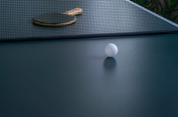 Close-up table tennis ball and racket on the table for the game.