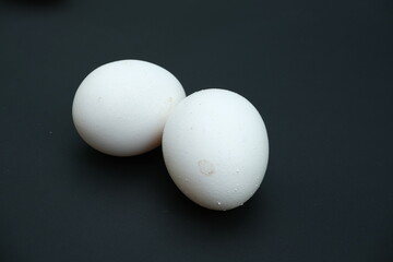 Two Chicken eggs on black background ,close up view