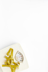 White floor weight scales and tape measure, top view
