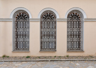 Three adjacent decorated wrought iron arched windows at the courtyard of Dolmabahce Palace, Besiktas district, Istanbul, Turkey