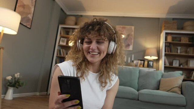 Young woman listen music on headphones prepare for training at home