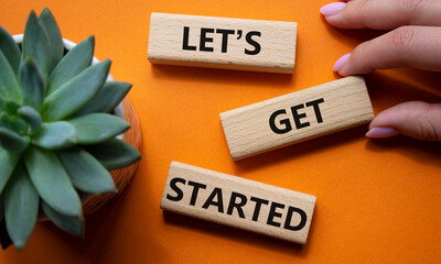 Lets get started symbol. Concept words Lets get started on wooden blocks. Beautiful orange...