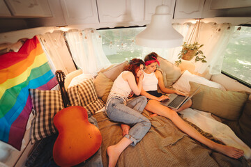 Portrait of a cute lesbian couple. Two girls spend time tenderly together in a camper trailer. Love and attitude. LGBT concept
