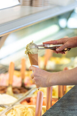 Close-up of a woman preparing and ice cream with one flavor