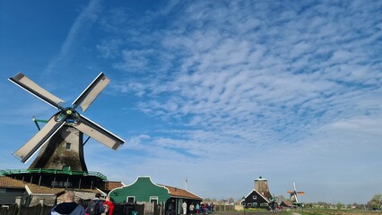Fototapeta na wymiar Zaanse Schans, April 22, 2023: Netherlands rural lanscape Windmills at famous tourist site. park and fields landscape in Zaandam, north Holland, aerial view in sunrise light.