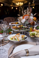 decorated table with white dishes and napkins with various dishes. table with various dishes