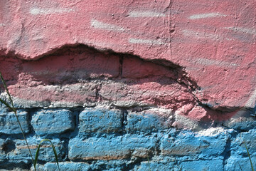 Colored pink and blue wall stripped to brick.. urban background