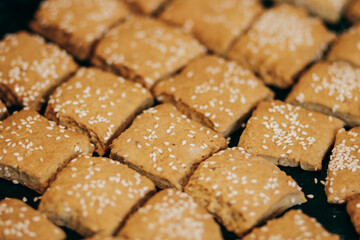 Square homemade cookies with sesame seeds.