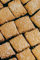 Square homemade cookies with sesame seeds.