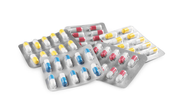 Many blisters with different pills on white background