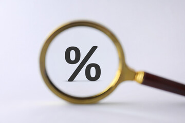 Percent sign on white background, view through magnifying glass