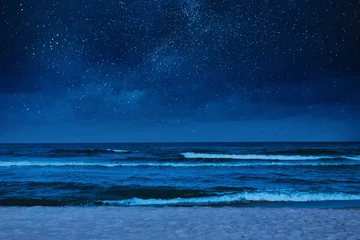Fototapeten Strand Sea waves rolling onto sandy beach under starry sky at night  © New Africa