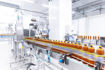 Brown plastic beer drink alcohol bottles move on brewery conveyor, modern production line