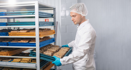 Worker man with sweets candy. Concept modern chocolate factory production line, food industry