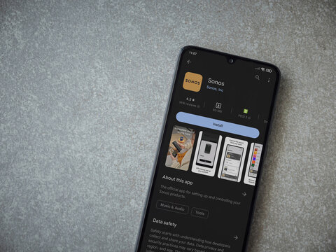 Lod, Israel - July 16,2023: Sonos app play store page on smartphone on ceramic stone background. Top view flat lay with copy space.