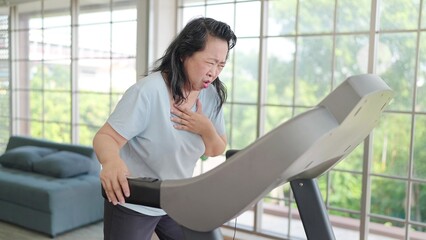Asian elderly women have chest pain while exercising on the machine at home. Elderly lifestyle,...