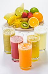 Sucos de frutas tropicais, frutos e suco em fundo branco