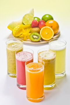 Sucos de frutas tropicais, frutos e suco em fundo branco